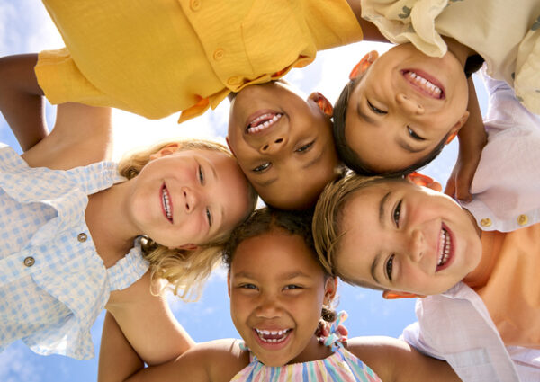 group of children smiling while looking face down at the camera